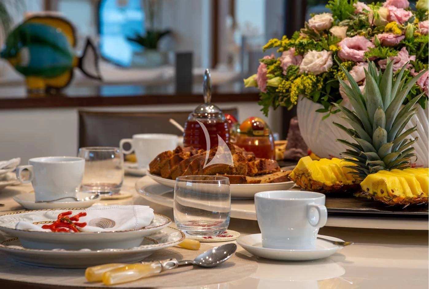 a table with plates and glasses aboard IRAVATI Yacht for Sale
