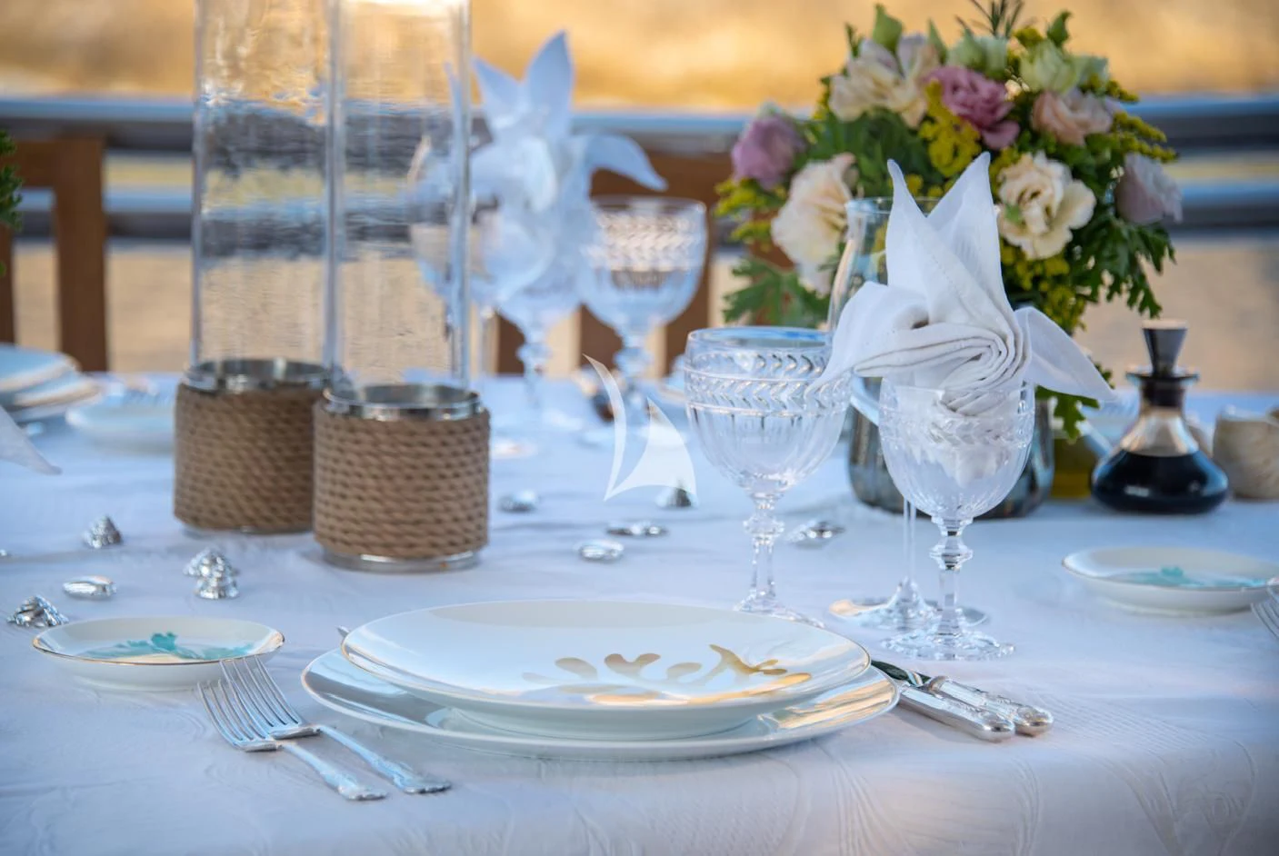 a table set with plates and glasses aboard IRAVATI Yacht for Sale