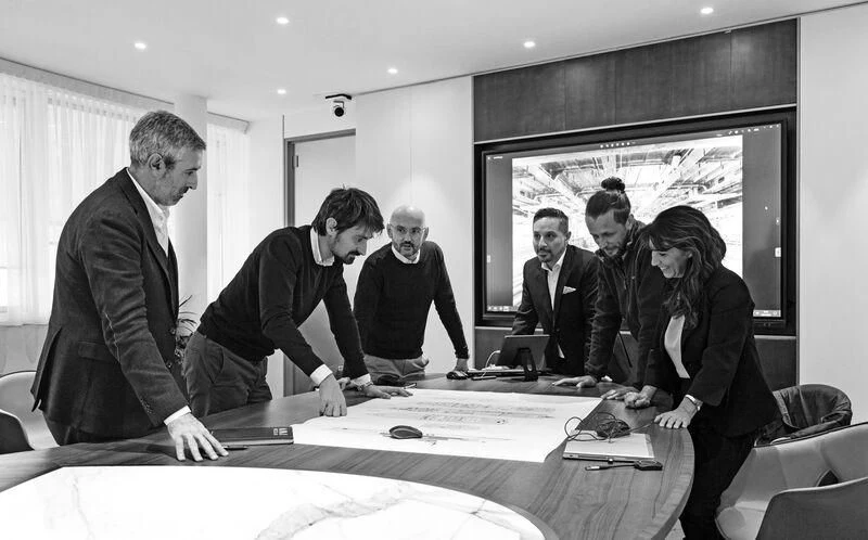 a group of people standing around a table looking at a screen aboard BRAVISSIMA Yacht for Sale
