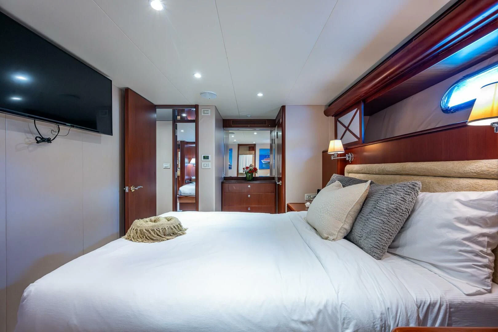 a bed with pillows and a television aboard LADY LORRAINE Yacht for Sale