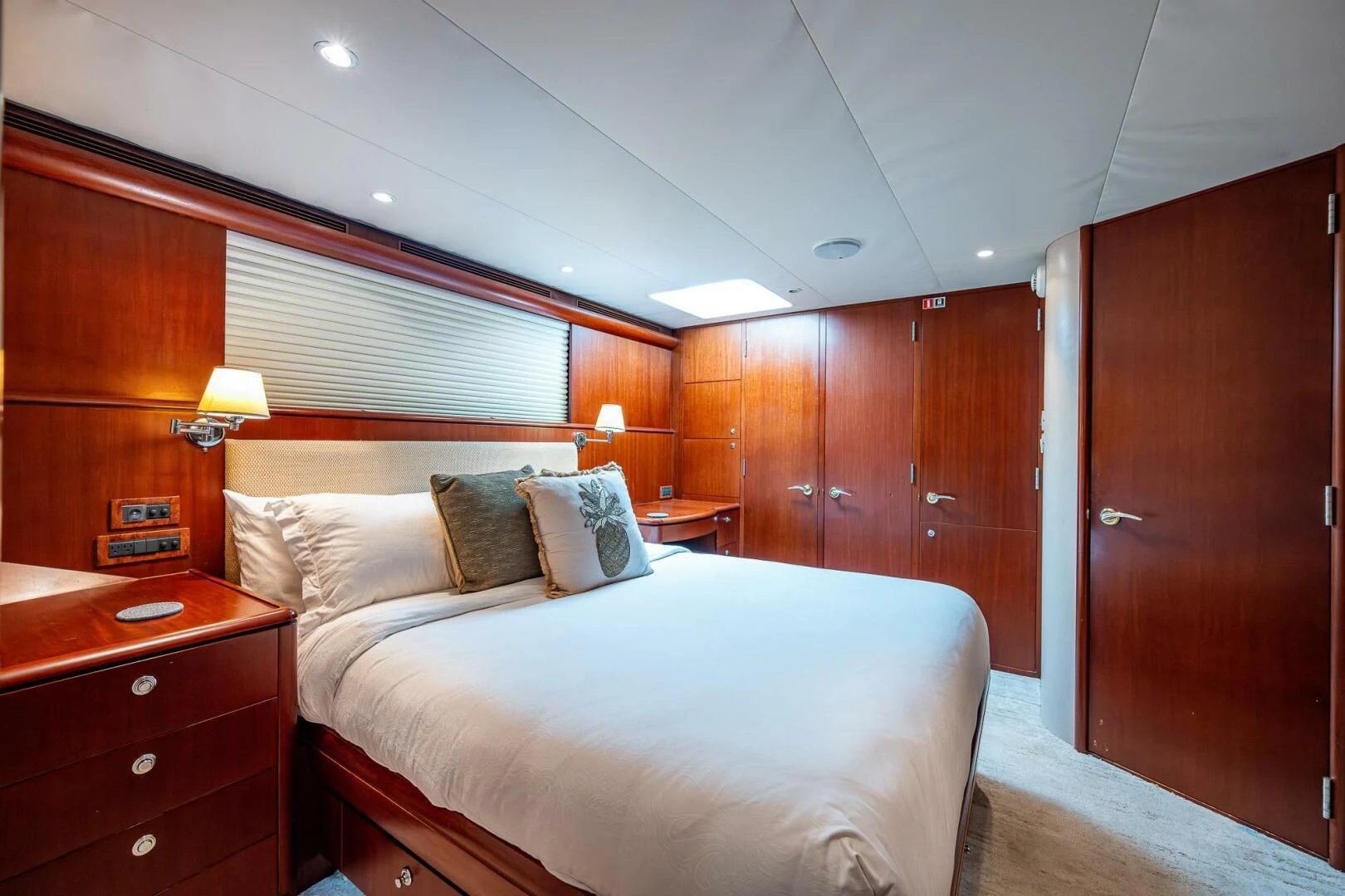 a bedroom with a bed and a wood cabinet aboard LADY LORRAINE Yacht for Sale