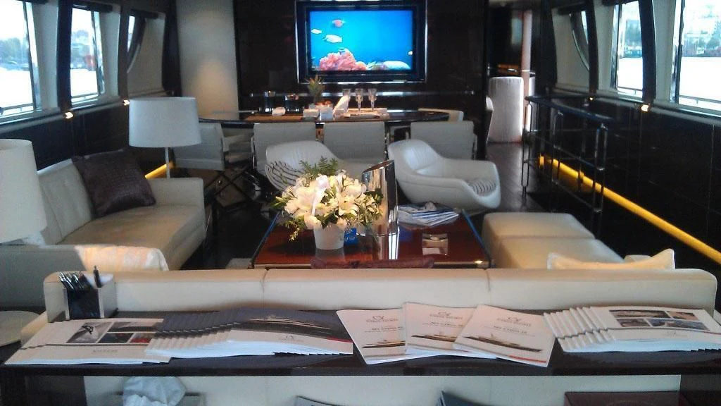 a room with a tv and a table with papers on it aboard CYRUS ONE Yacht for Sale