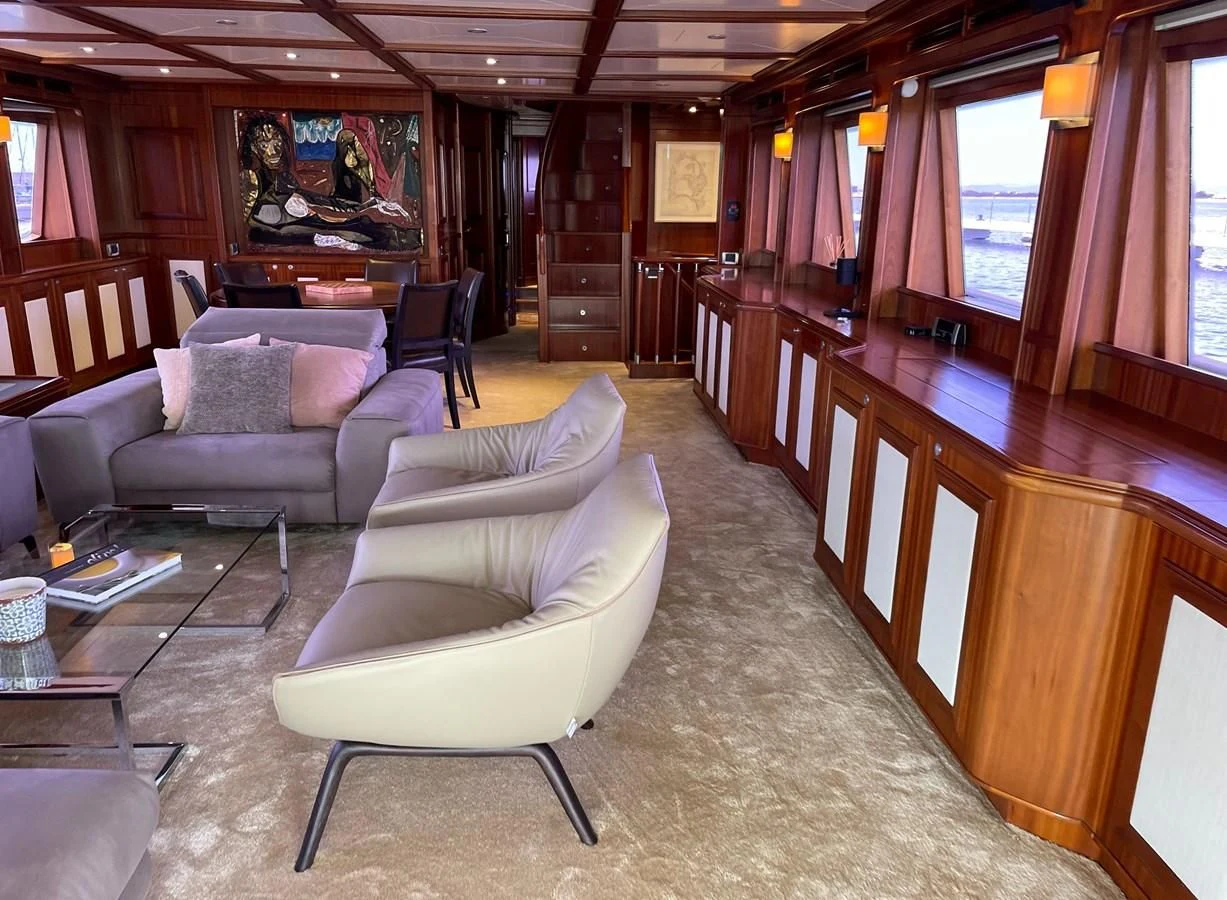 a living room with a couch and a table aboard BIM Yacht for Sale