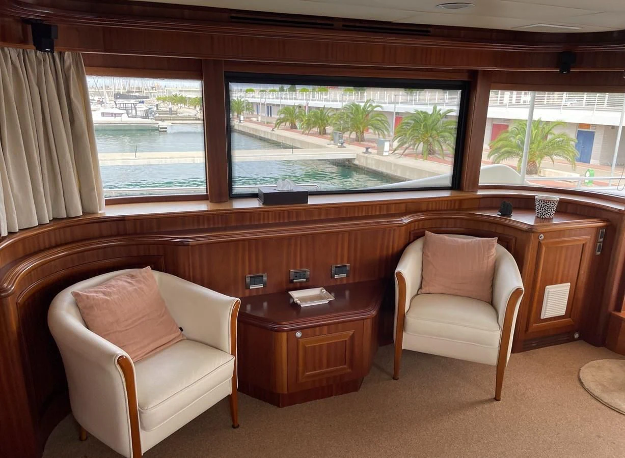 a room with a chair and a desk and a window aboard BIM Yacht for Sale