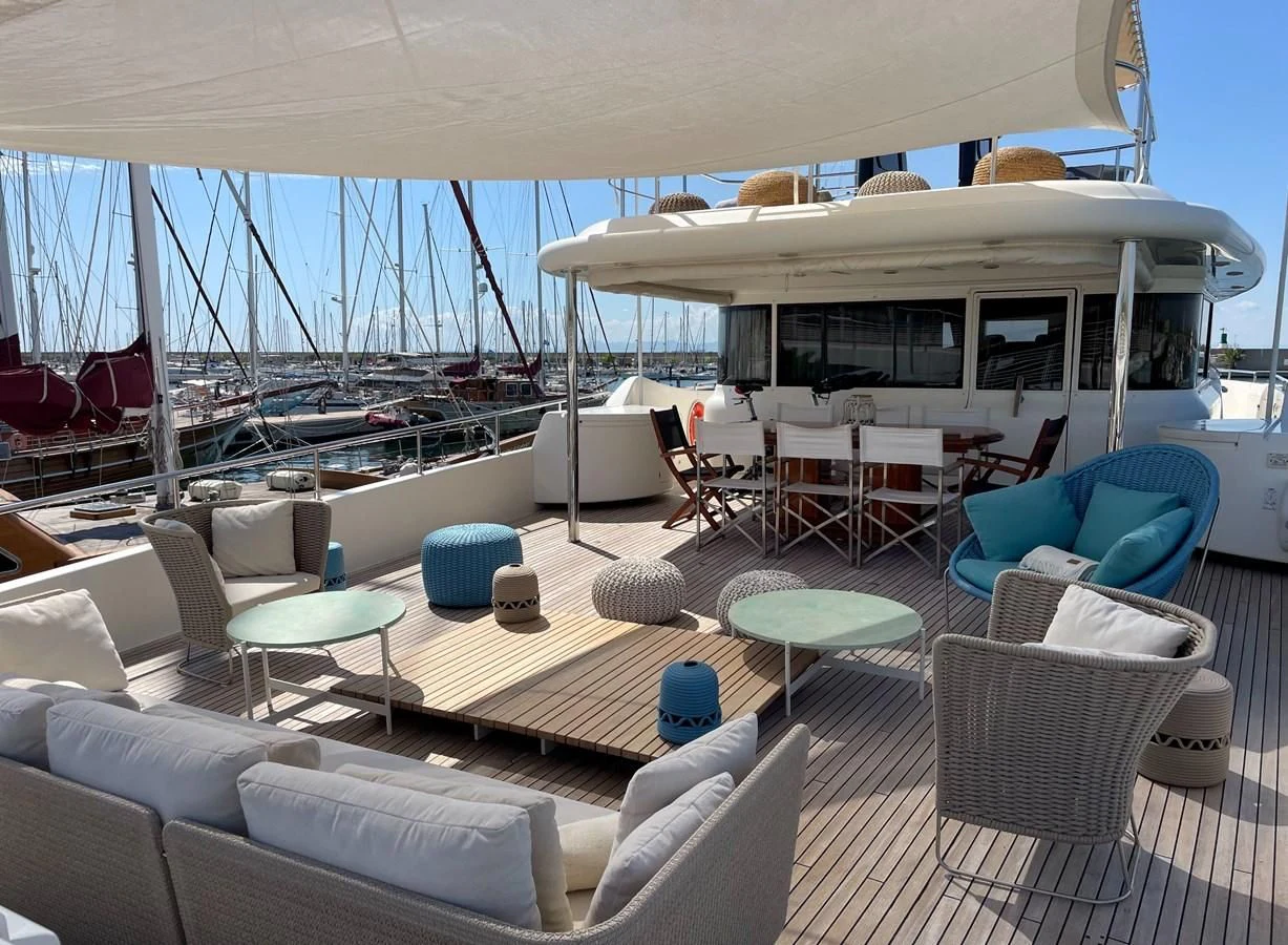 a lounge area with a large white umbrella and chairs aboard BIM Yacht for Sale