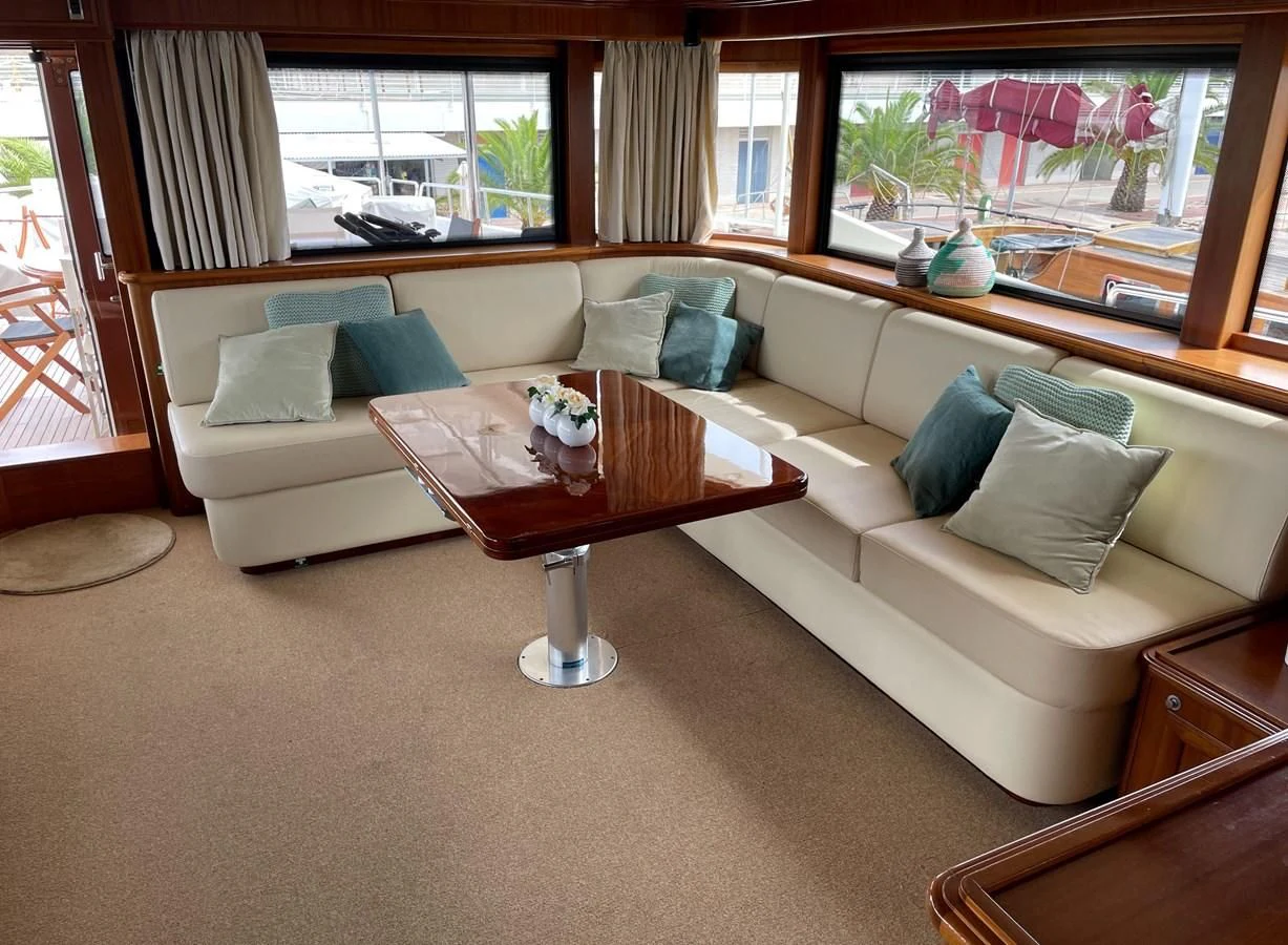 a living room with a couch and a table aboard BIM Yacht for Sale