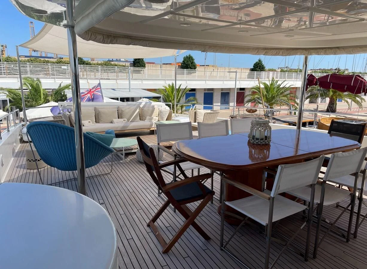 a table and chairs on a patio aboard BIM Yacht for Sale