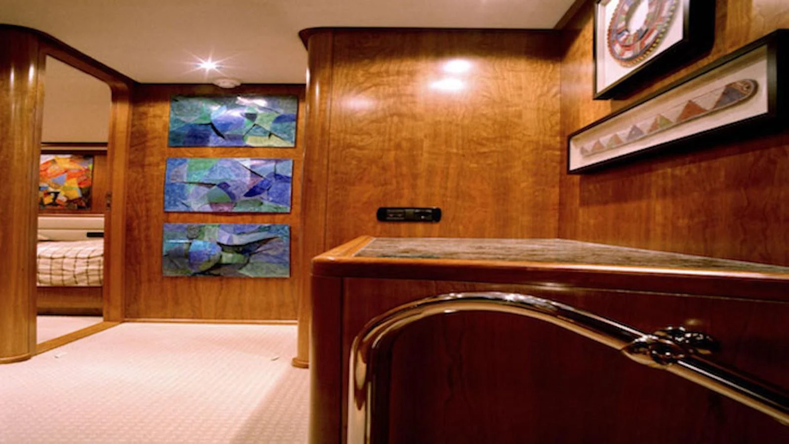 a room with a large mirror and paintings on the wall aboard MAVERICK Yacht for Sale