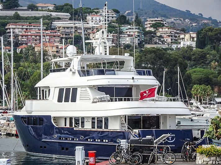 a large white boat in a harbor aboard SMILING T Yacht for Sale