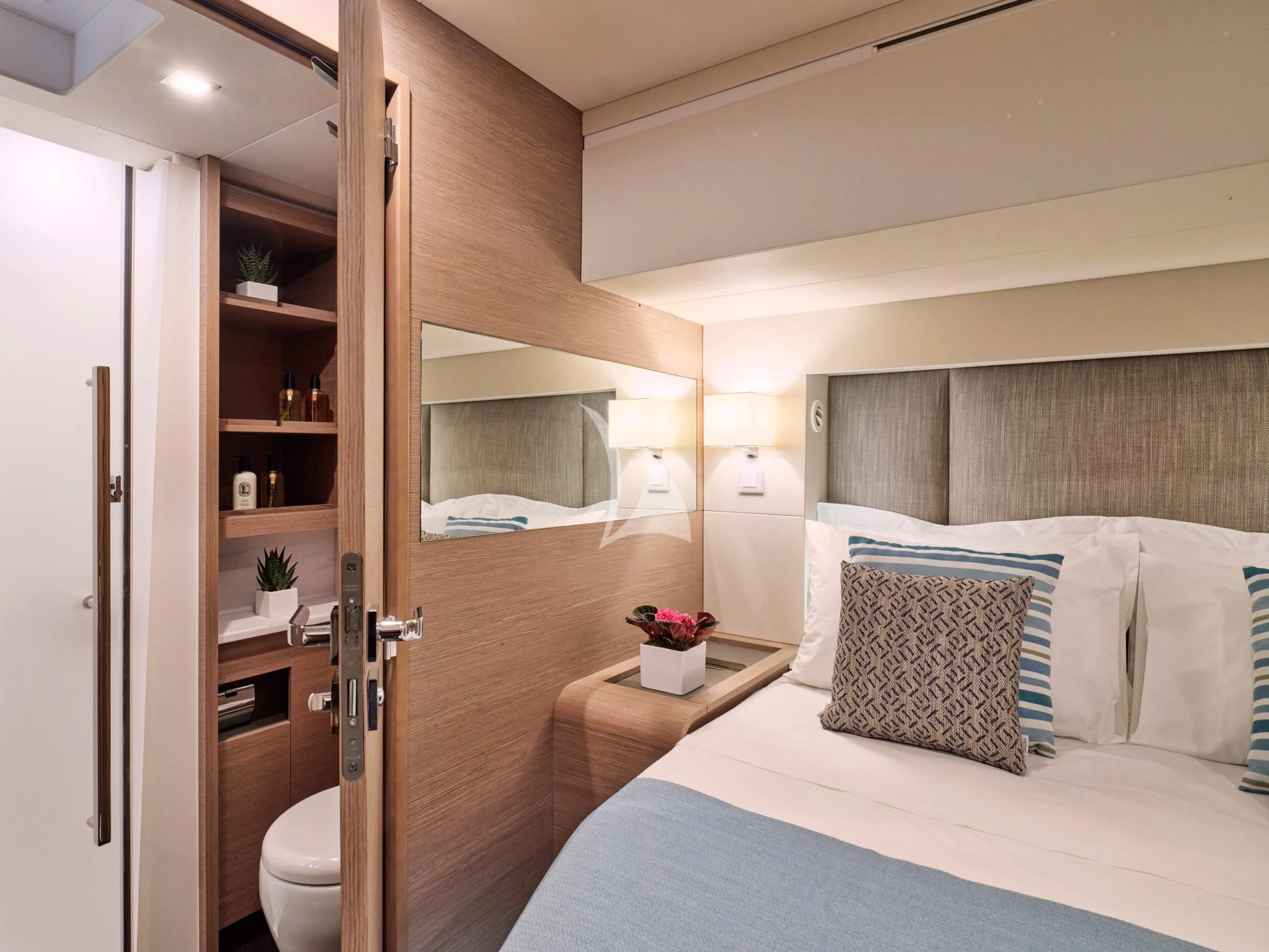 a bedroom with a bed and a mirror aboard APHAEA Yacht for Charter