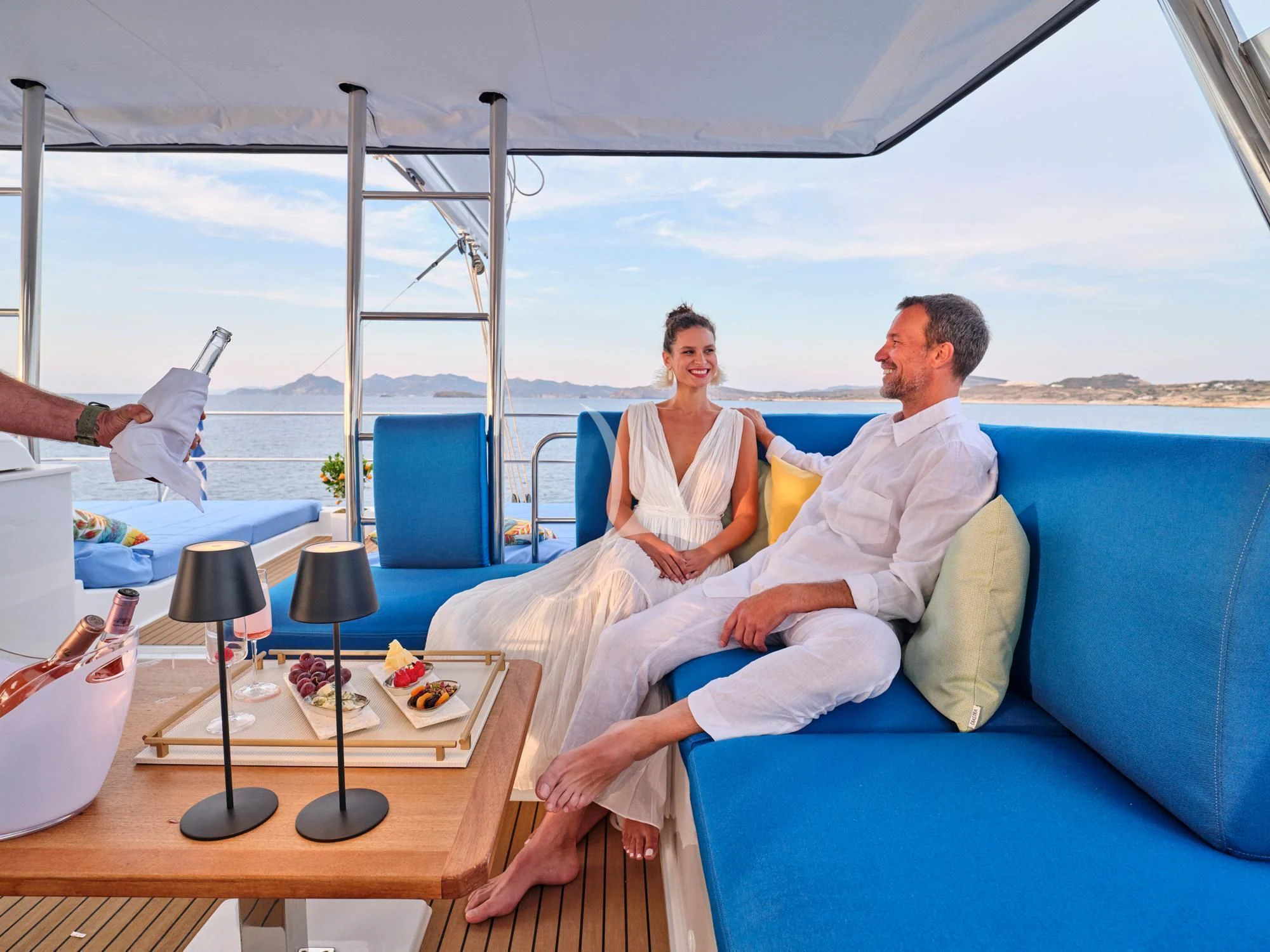 a man and a woman sitting on a couch aboard APHAEA Yacht for Charter