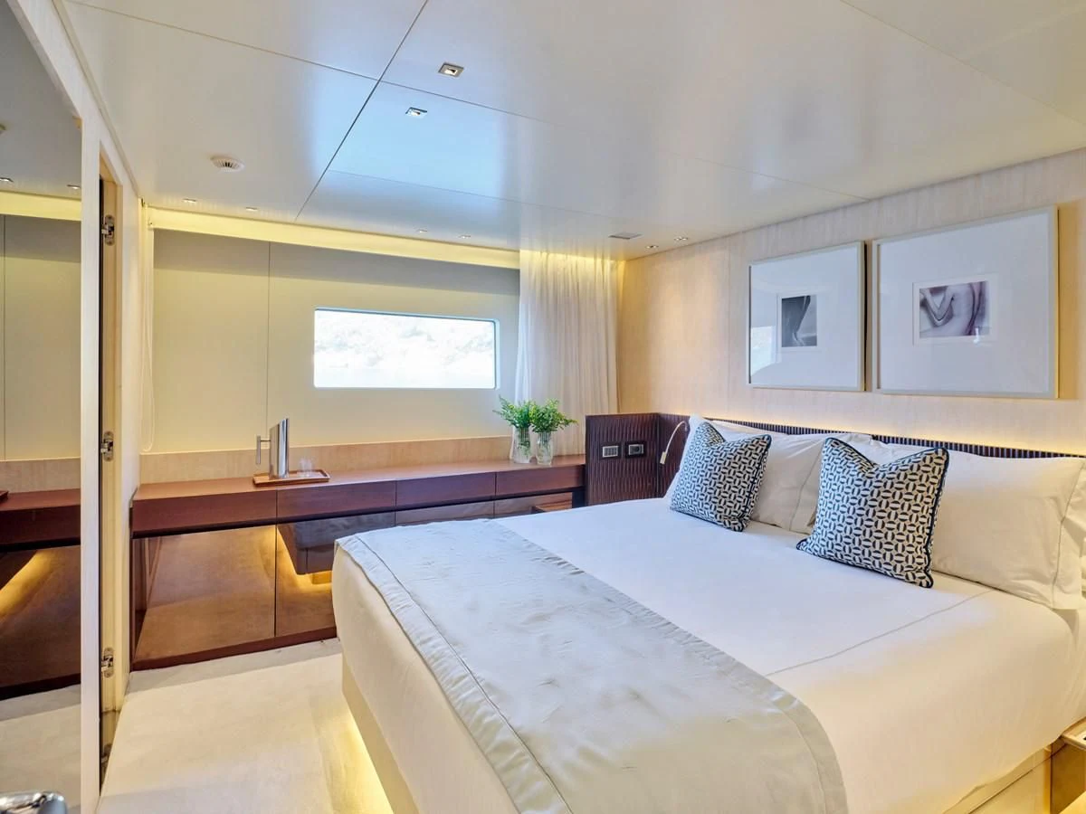 a bedroom with a bed and a desk aboard RARE DIAMOND Yacht for Sale