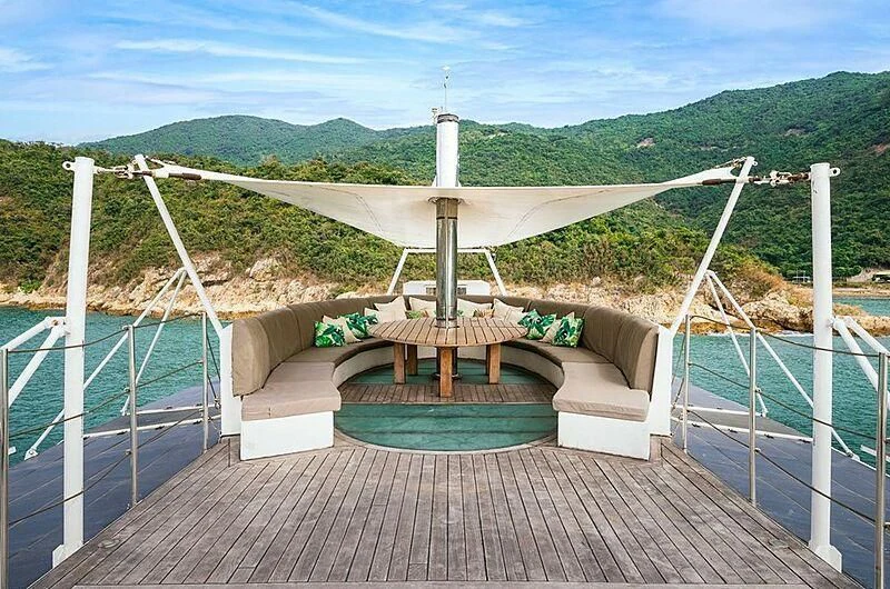 a deck with a pool and a deck with a picnic table and a view of mountains aboard DOT Yacht for Sale