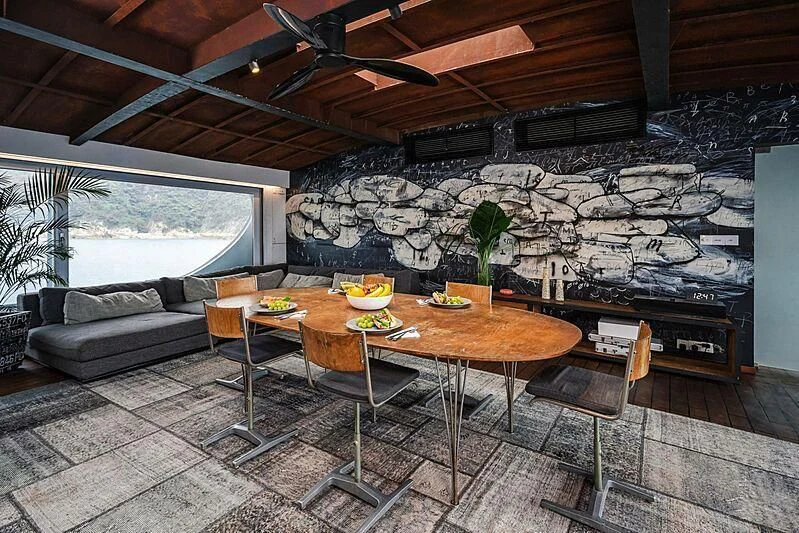 a modern looking living room with a large stone wall aboard DOT Yacht for Sale