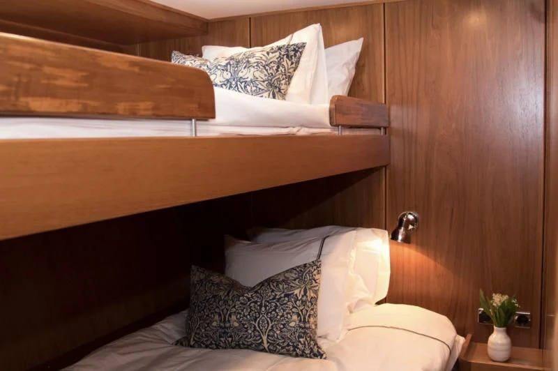 a bed with a wooden headboard aboard STELLA NOVA Yacht for Sale