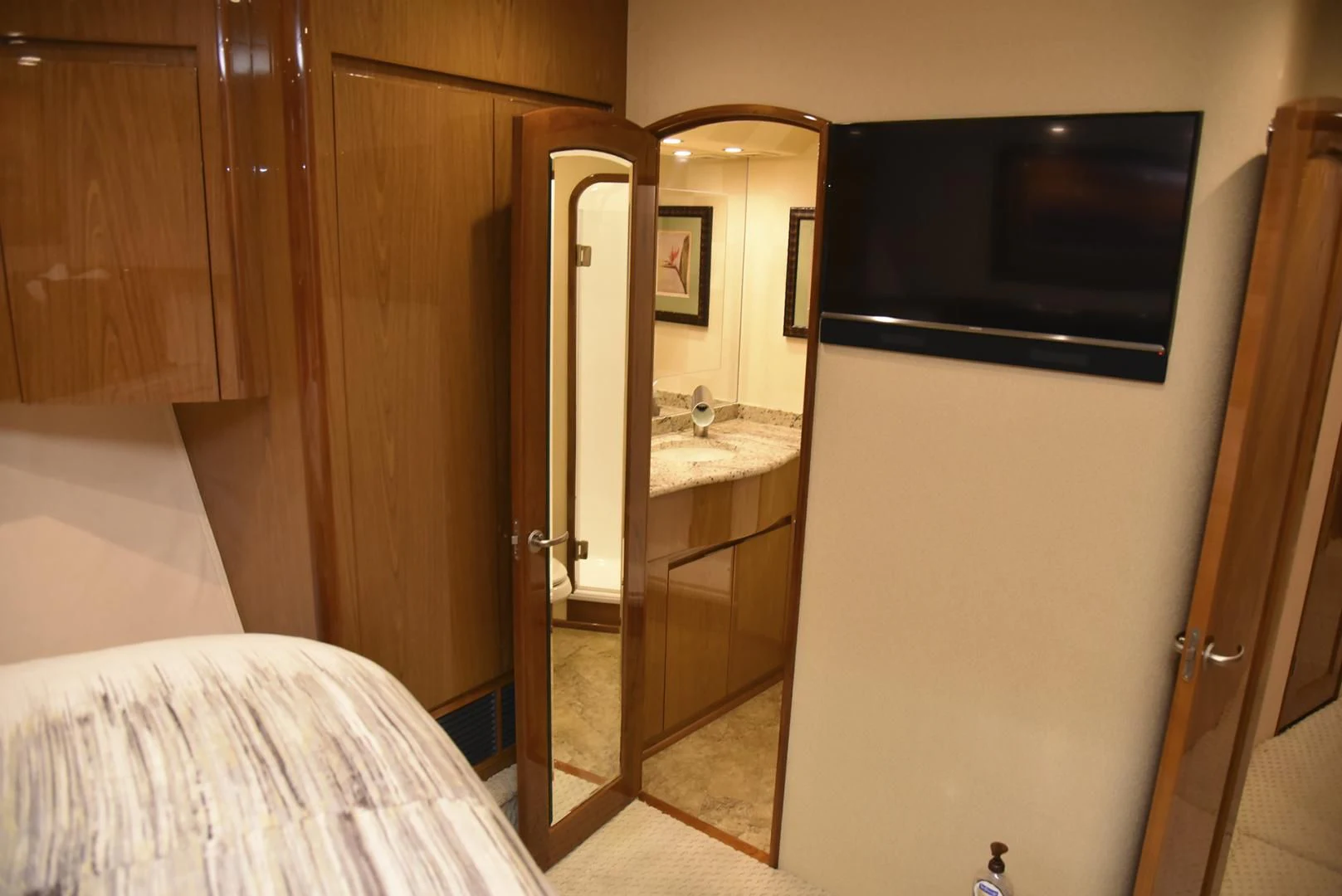 a bathroom with a tv and a bed aboard SALTY K Yacht for Sale