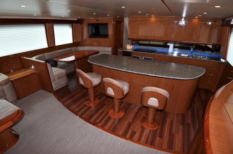 a large kitchen with a bar and chairs aboard SALTY K Yacht for Sale