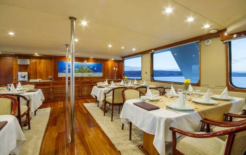 a room with tables and chairs aboard INTEGRITY Yacht for Sale