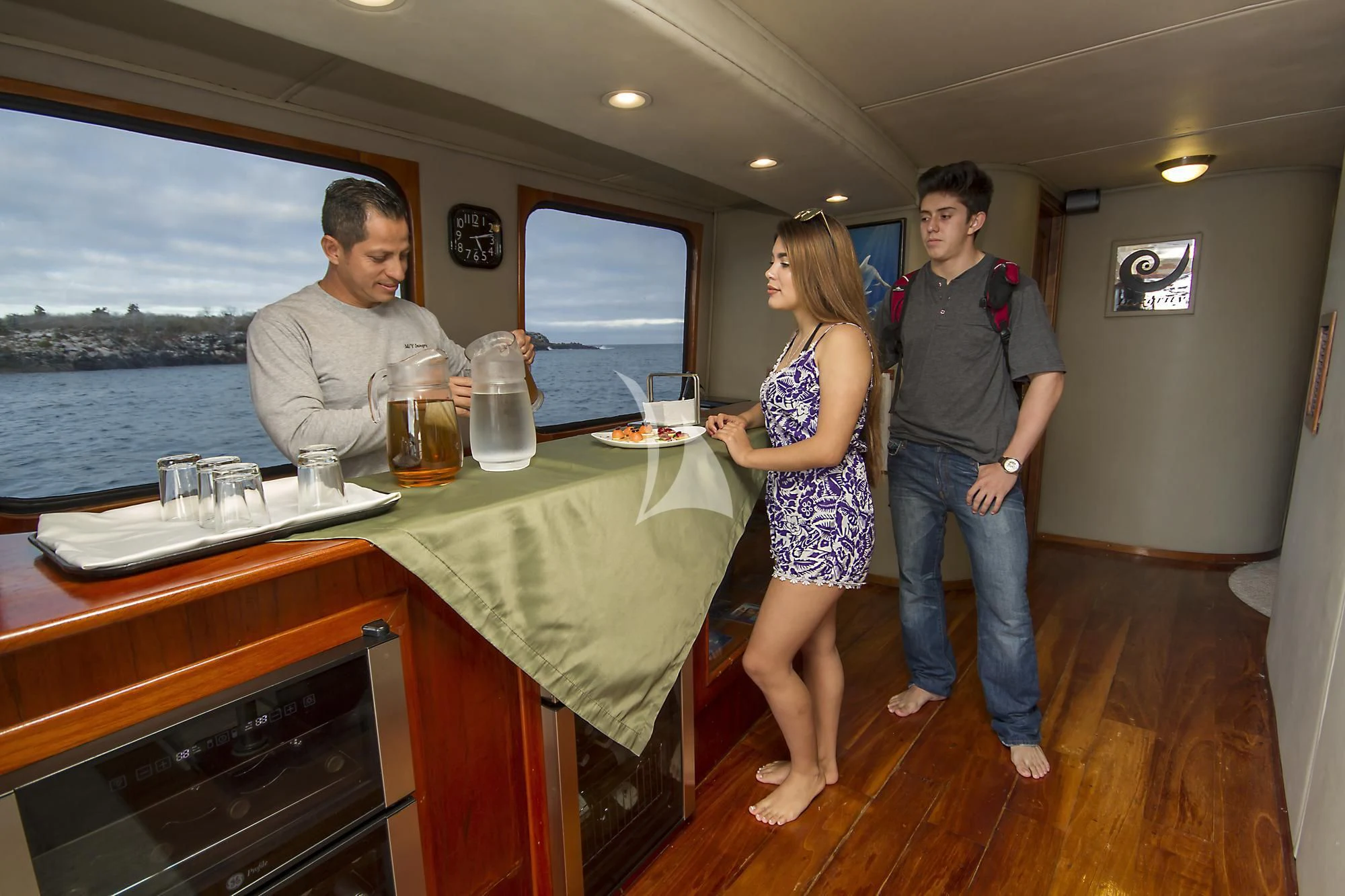 a group of people standing around a table with drinks on it aboard INTEGRITY Yacht for Sale