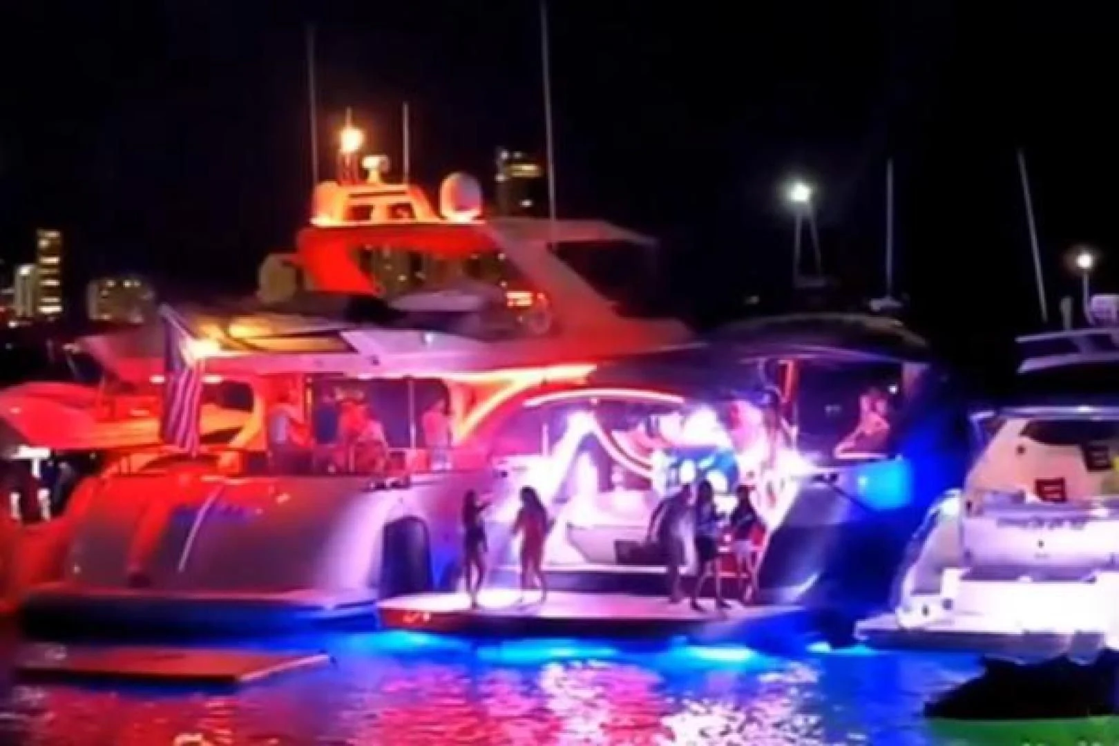 a group of people on a stage with a car and lights aboard GHOST Yacht for Sale