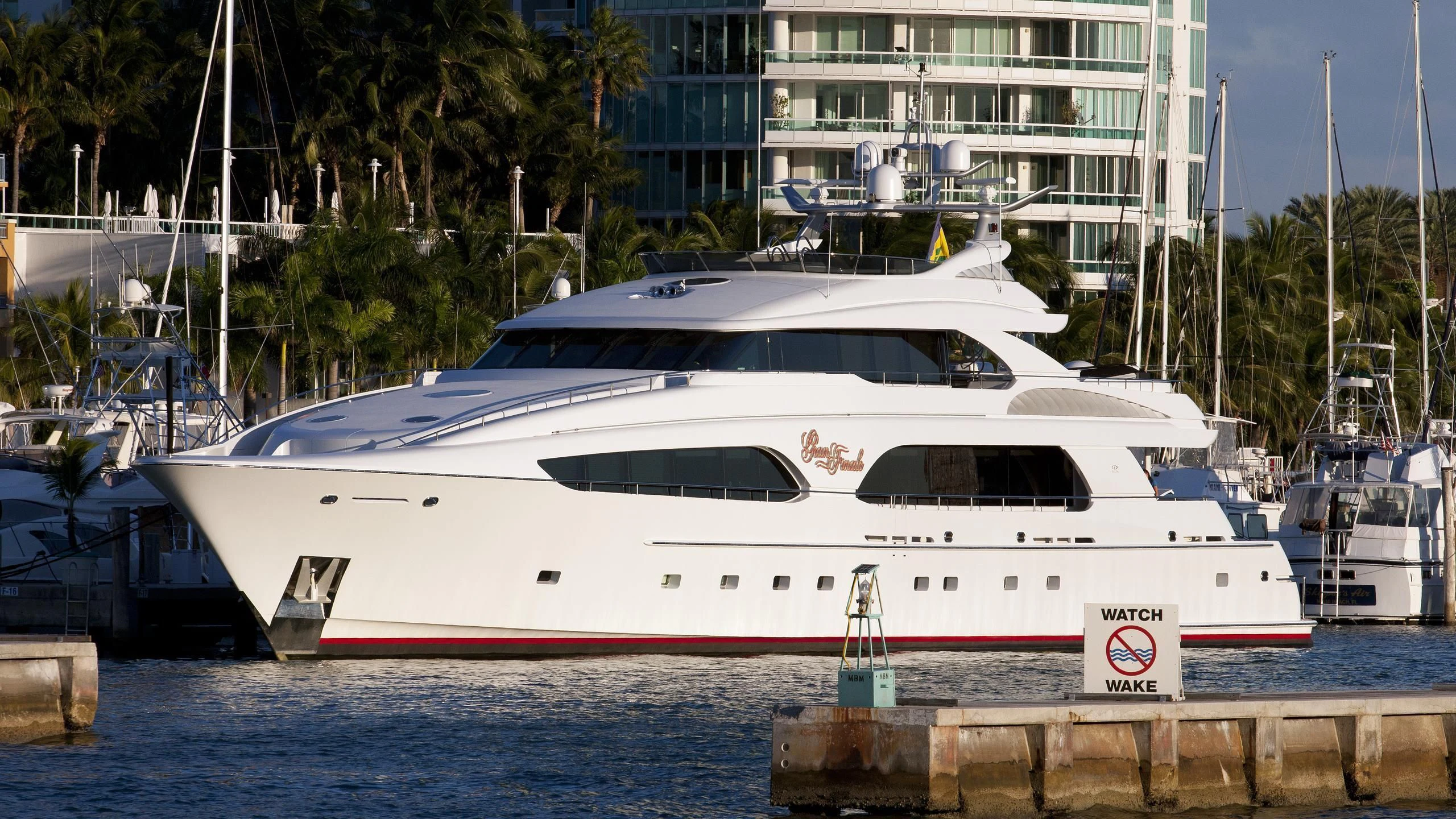 a white yacht in a harbor aboard DRIVEN Yacht for Sale