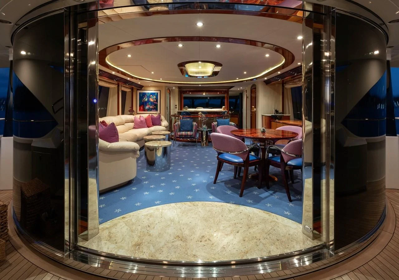 a large living room with a large glass wall aboard DRIVEN Yacht for Sale