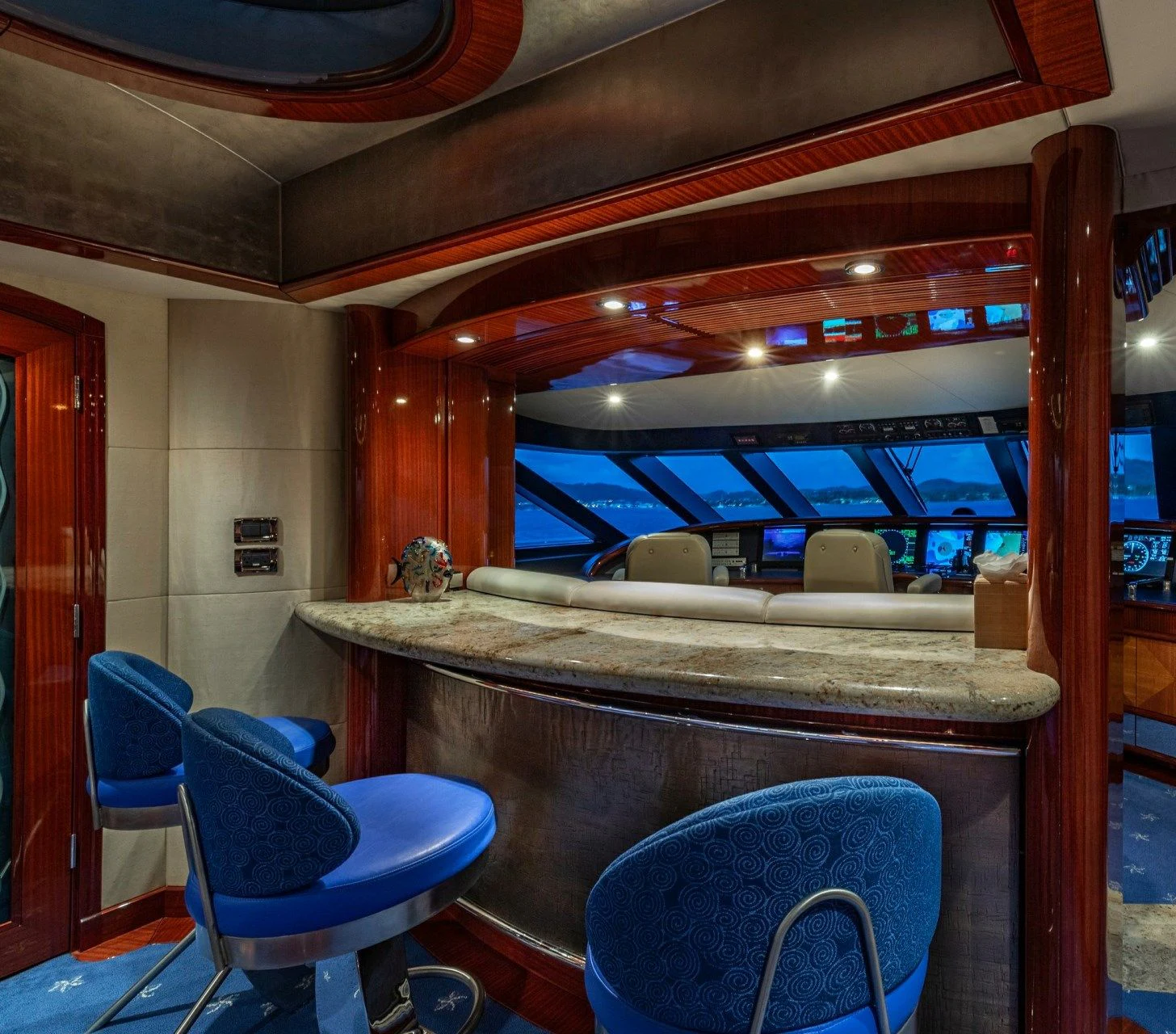 a room with a bar and chairs aboard DRIVEN Yacht for Sale