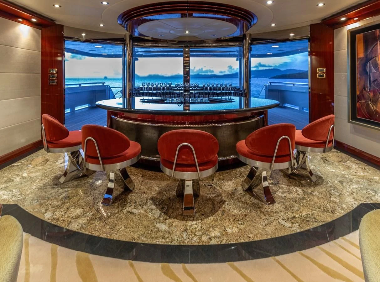 a bar with red chairs aboard DRIVEN Yacht for Sale