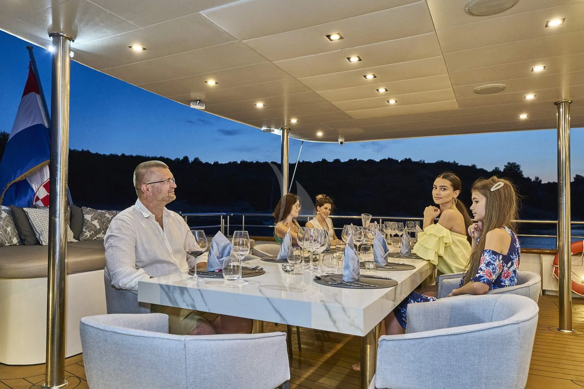 a group of people sitting at a table aboard DALMATINO Yacht for Sale