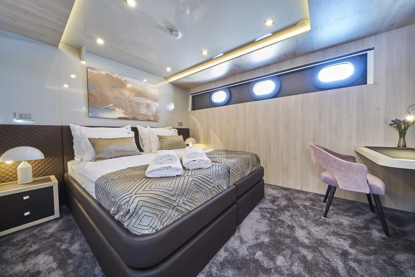 a room with a bed and a chair aboard DALMATINO Yacht for Sale