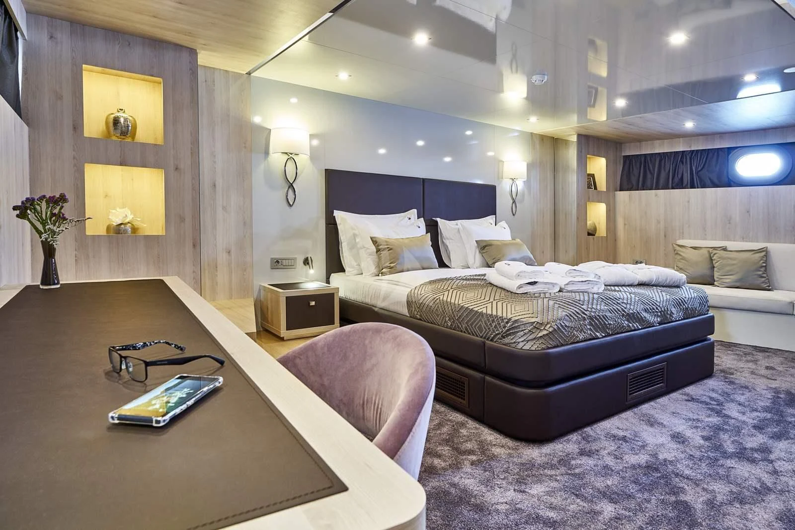 a room with a bed and a coffee table aboard DALMATINO Yacht for Sale