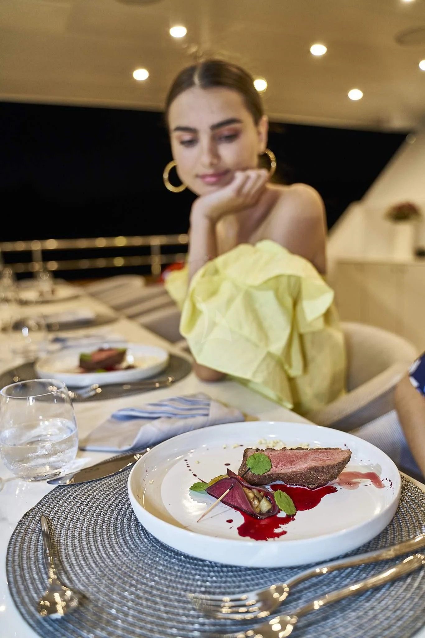 a woman sitting at a table with a plate of food aboard DALMATINO Yacht for Sale