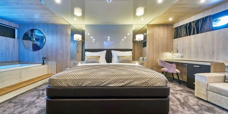 a large bedroom with a bed and a desk aboard DALMATINO Yacht for Sale