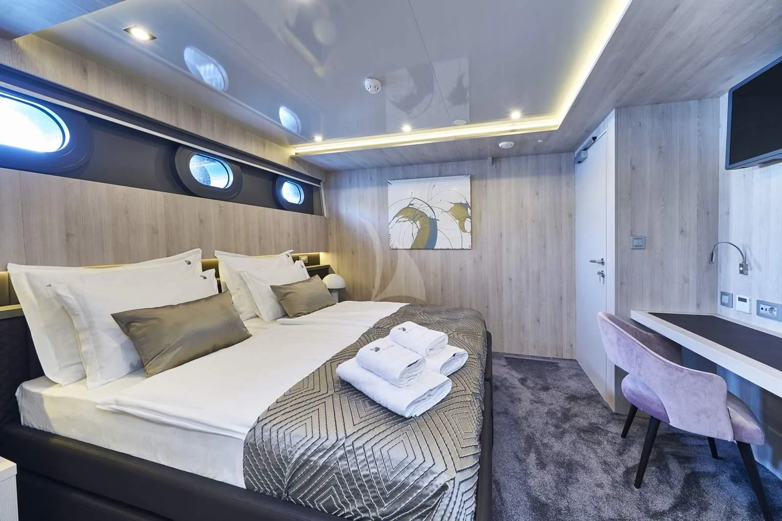 a room with a bed and a chair aboard DALMATINO Yacht for Sale