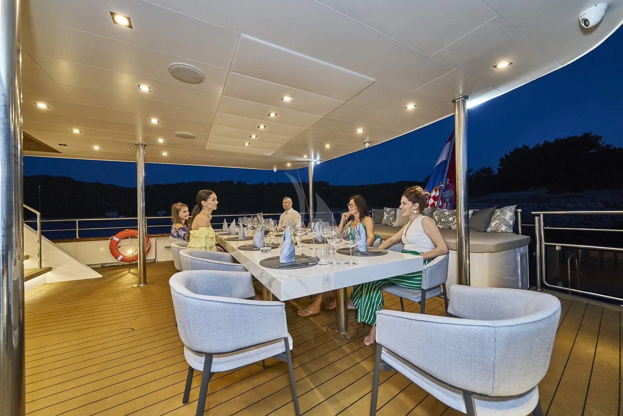 a group of people sitting around a table aboard DALMATINO Yacht for Sale