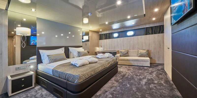 a room with a bed and a couch aboard DALMATINO Yacht for Sale