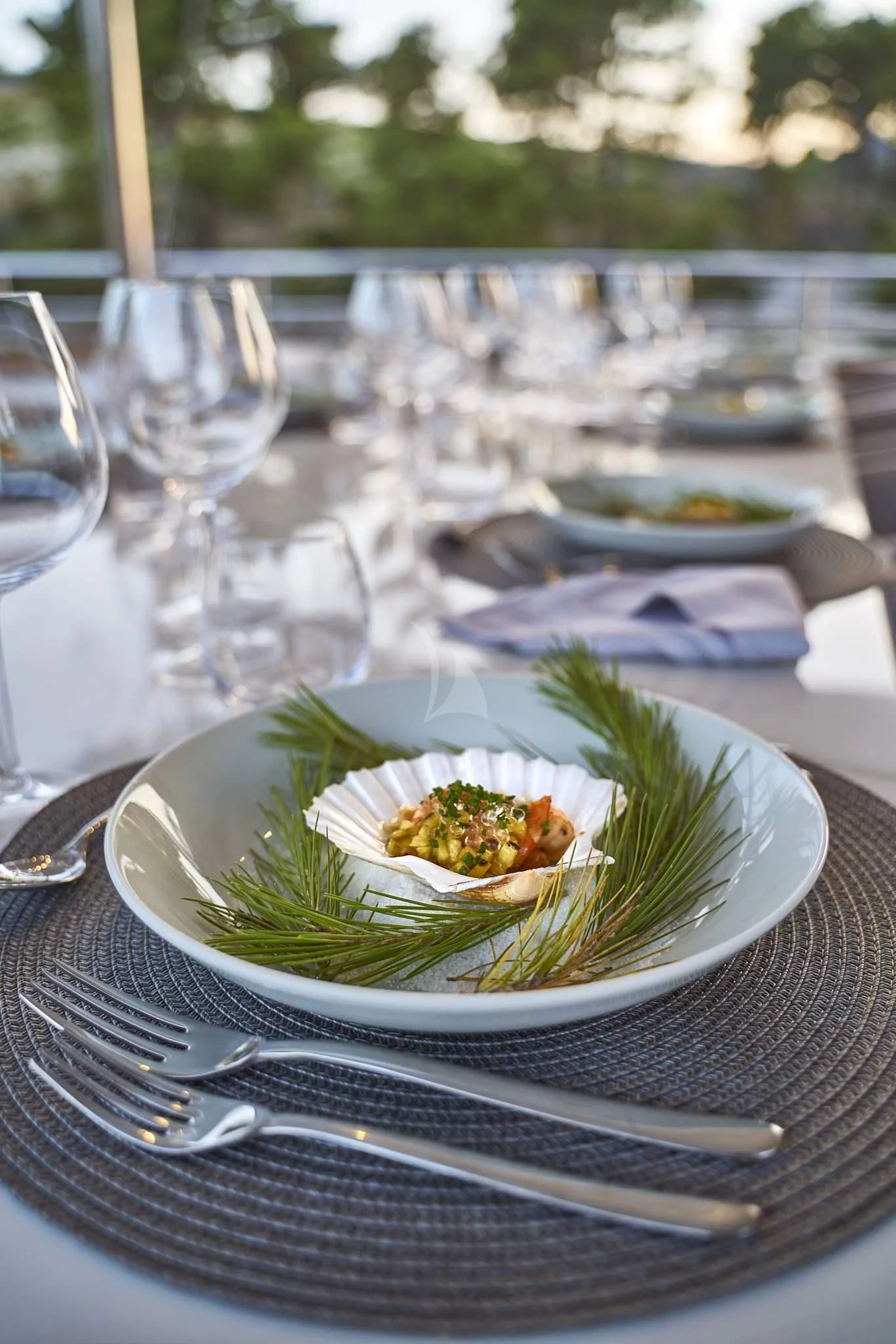 a plate of food and glasses on a table aboard DALMATINO Yacht for Sale