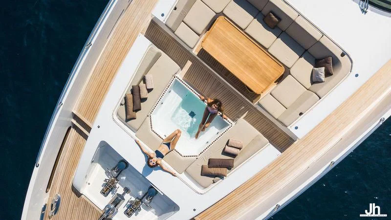 a person sitting on a chair in a room with a large mirror aboard QHT Yacht for Sale
