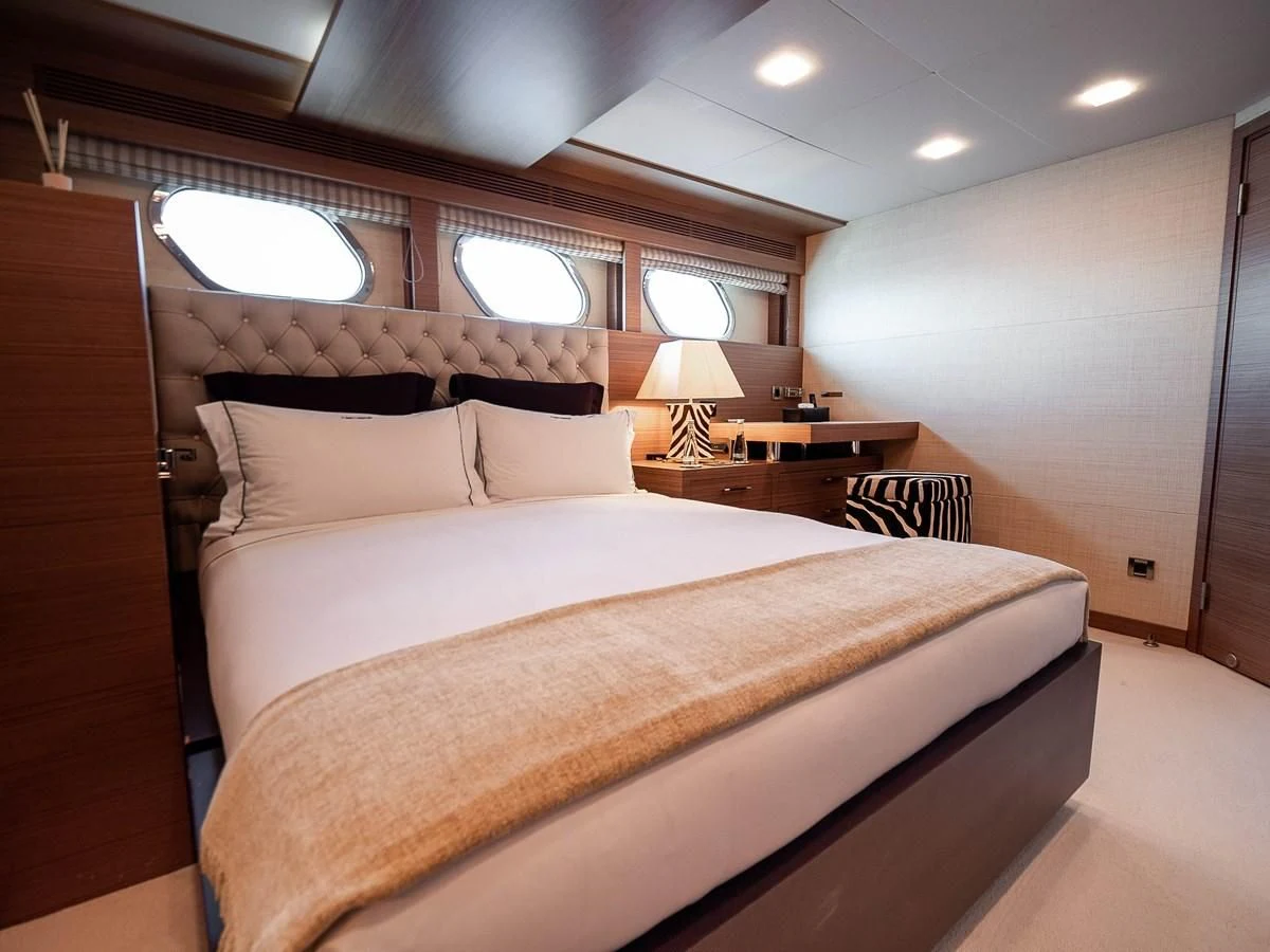 a bed with a white comforter aboard QHT Yacht for Sale