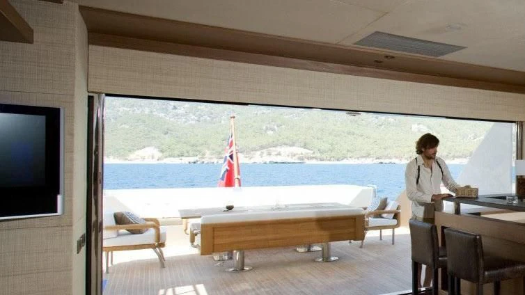 a person sitting at a table in a restaurant aboard QHT Yacht for Sale