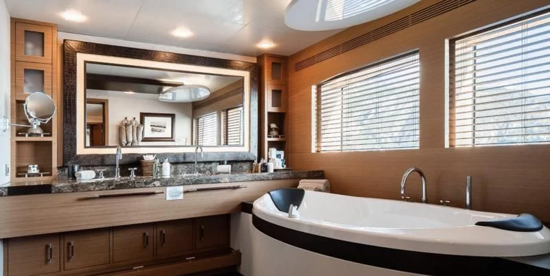 a large bathroom with a large mirror aboard QHT Yacht for Sale