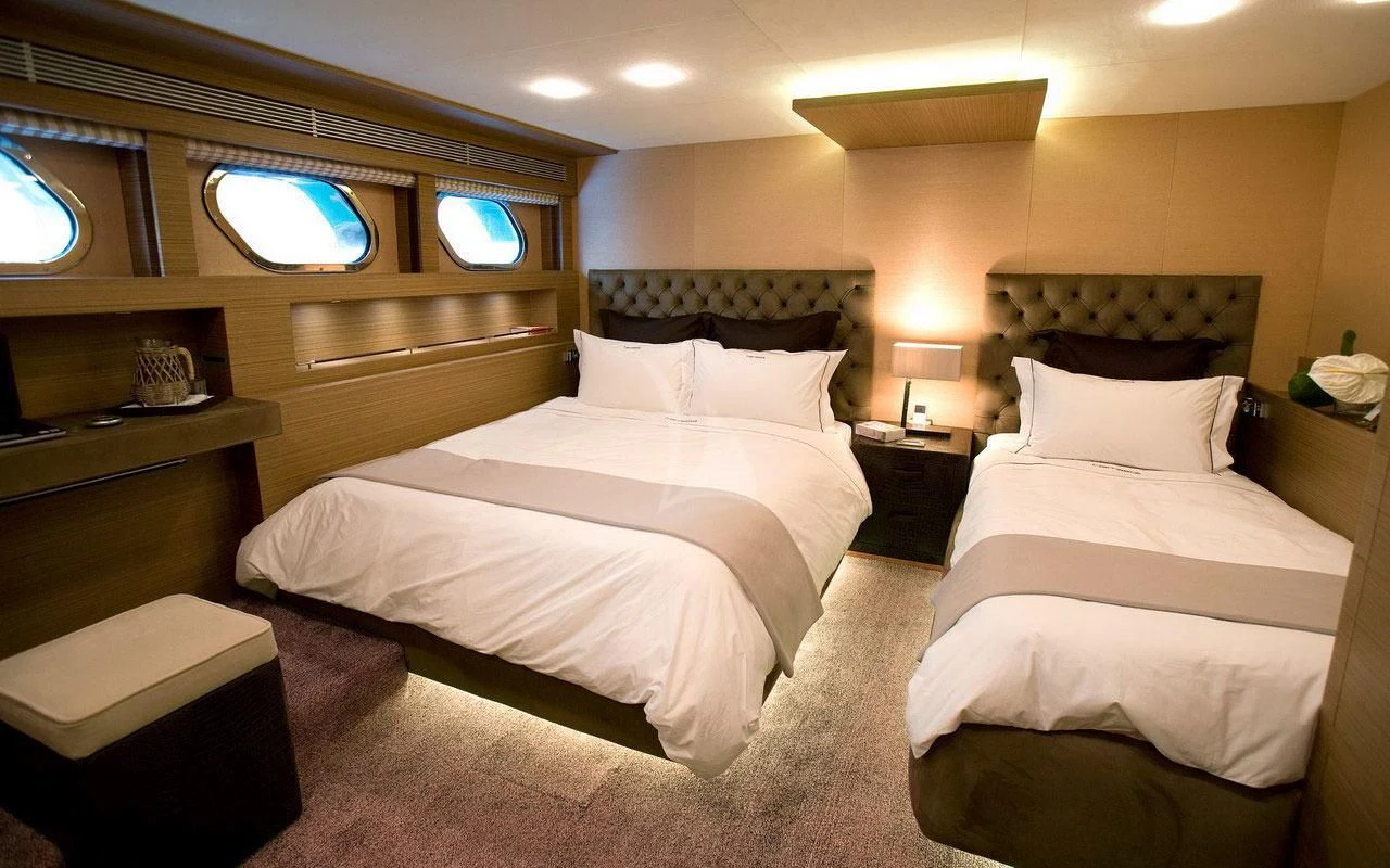 a room with three beds aboard QHT Yacht for Sale