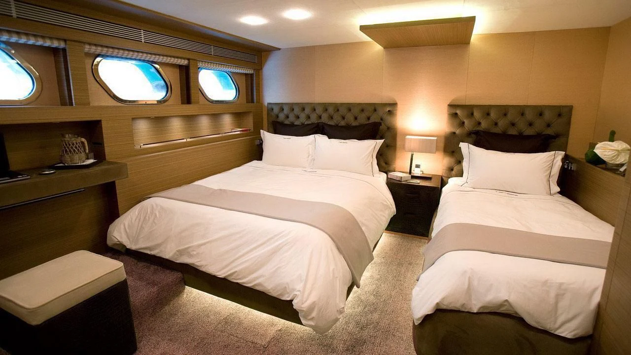 a room with three beds aboard QHT Yacht for Sale