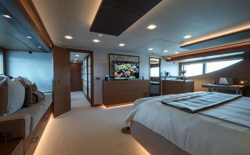 a room with a bed and a desk aboard QHT Yacht for Sale