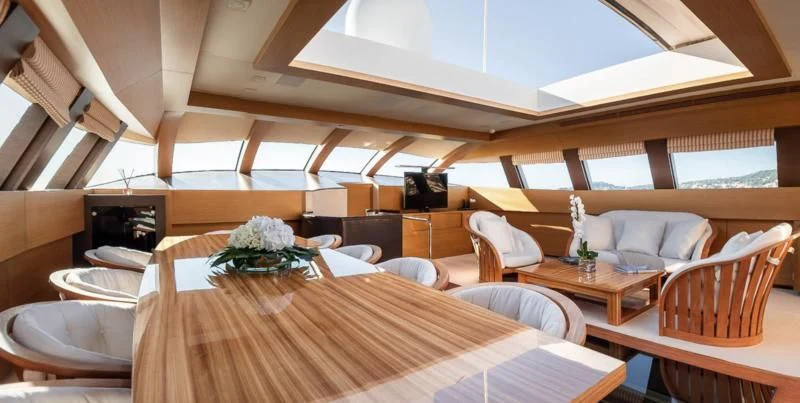 a room with a table and chairs aboard QHT Yacht for Sale