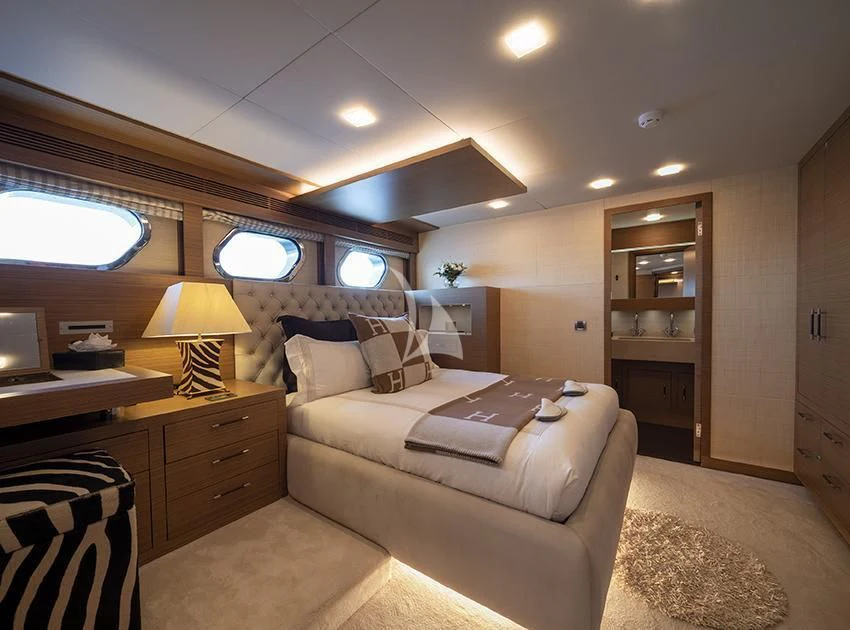 a bedroom with a bed and a desk aboard QHT Yacht for Sale