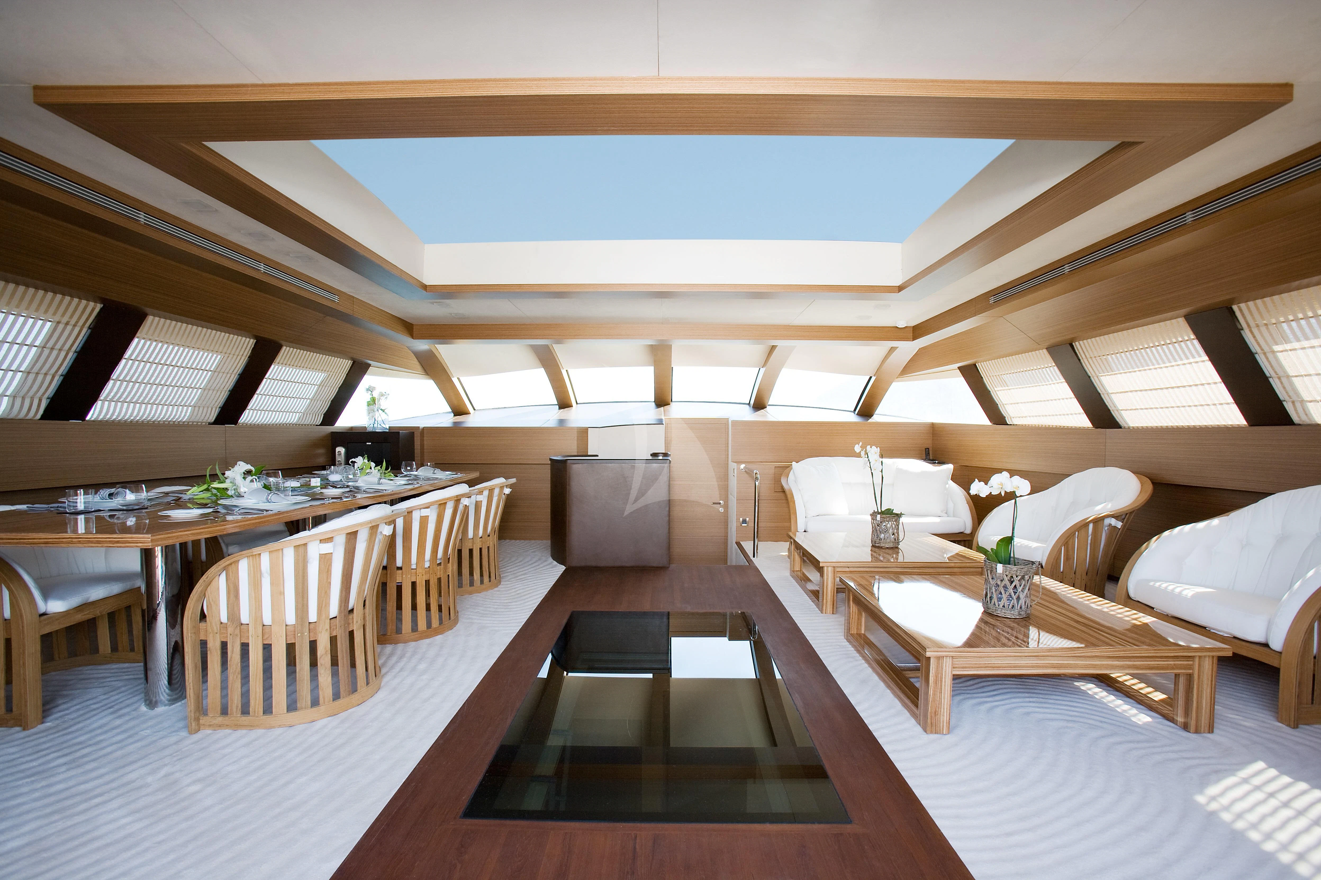 a room with tables and chairs aboard QHT Yacht for Sale