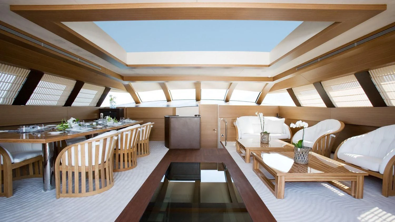a room with tables and chairs aboard QHT Yacht for Sale