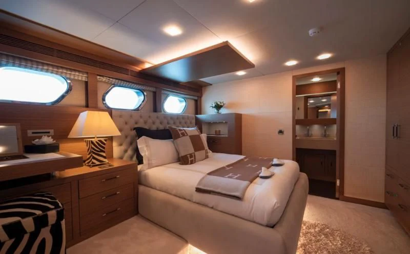 a bedroom with a bed and a desk aboard QHT Yacht for Sale