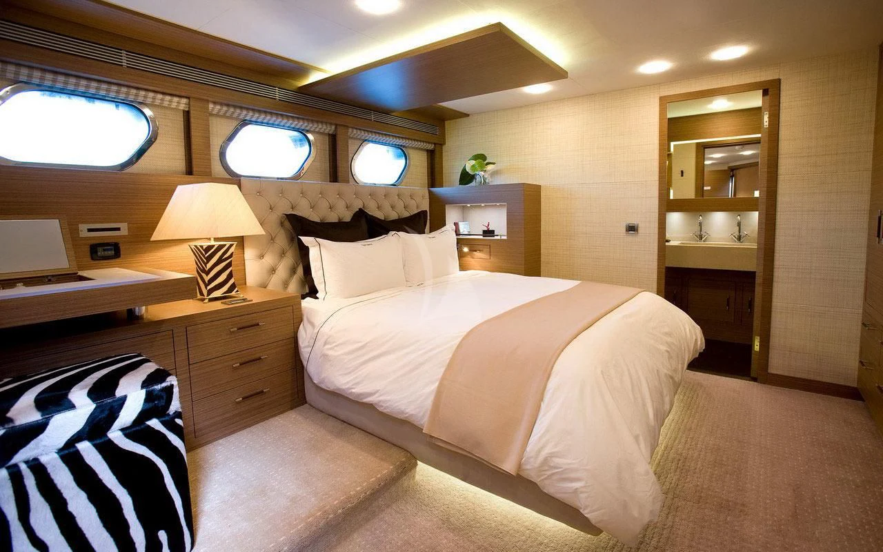 a bedroom with a bed and a desk aboard QHT Yacht for Sale